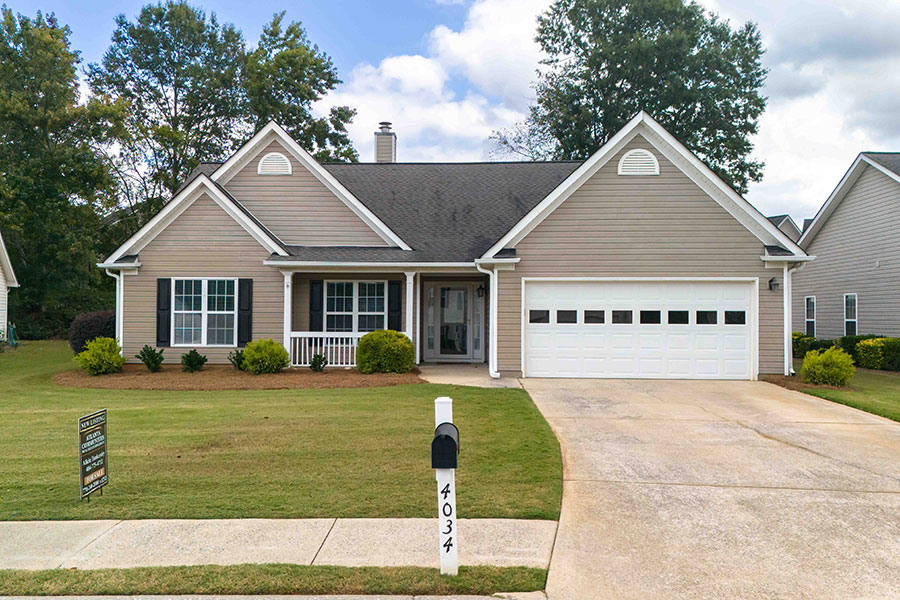 Beautiful single-story home for sale in Acworth, Georgia with beige siding, black shutters, two-car garage, and a well-maintained front lawn, perfect for families and first-time homebuyers.